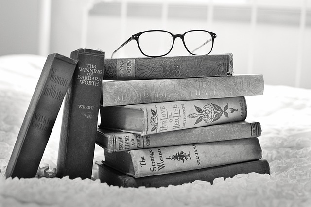 bookseller preparing curated stack of books with ribbon